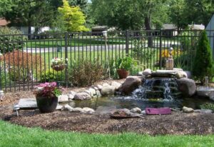 A serene backyard pond with a waterfall and rocks in Batavia, IL
