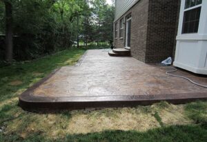 Concrete patio with a brick wall in Batavia, IL, showcases a blend of textures and outdoor living space
